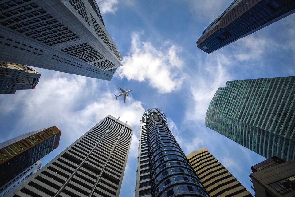 Ein Foto von Wolkenkratzern, die in die Höhe ragen. Die Gebäude stehen sinnbildlich für konkurrierende Unternehmen, die bei der Branchenstrukturanalyse analysiert werden.